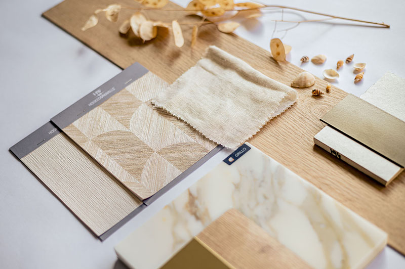 Moodboard met houtstalen, marmer, linnen en messing in warme tinten.